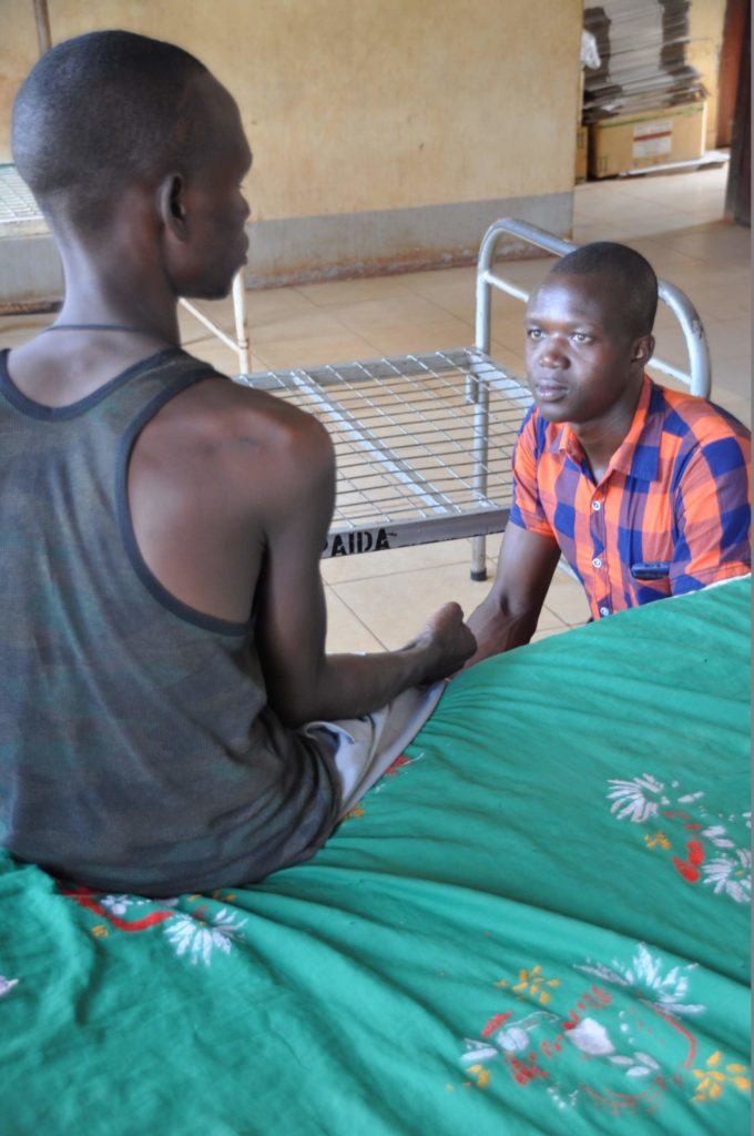 A health worker taught by Dr. Dan helps a patient