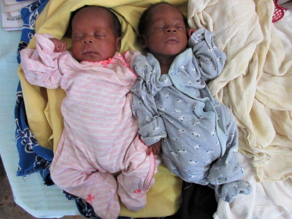 Twin, a baby girl and a baby boy sleeping beside one another