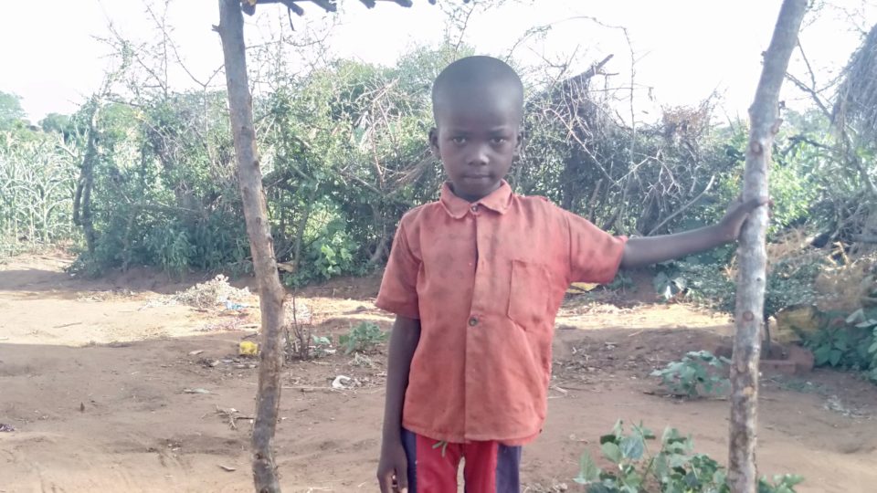 eric six years old kenya in front of his house