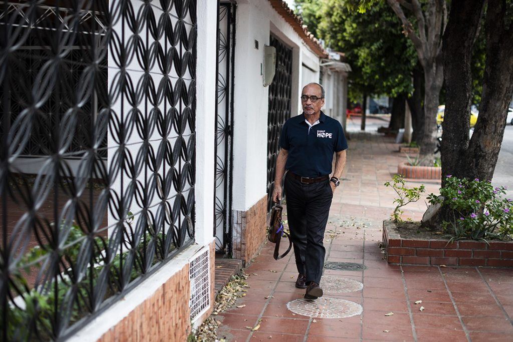 Dr. Atilio stands walks outside in front of a health center in Colombia