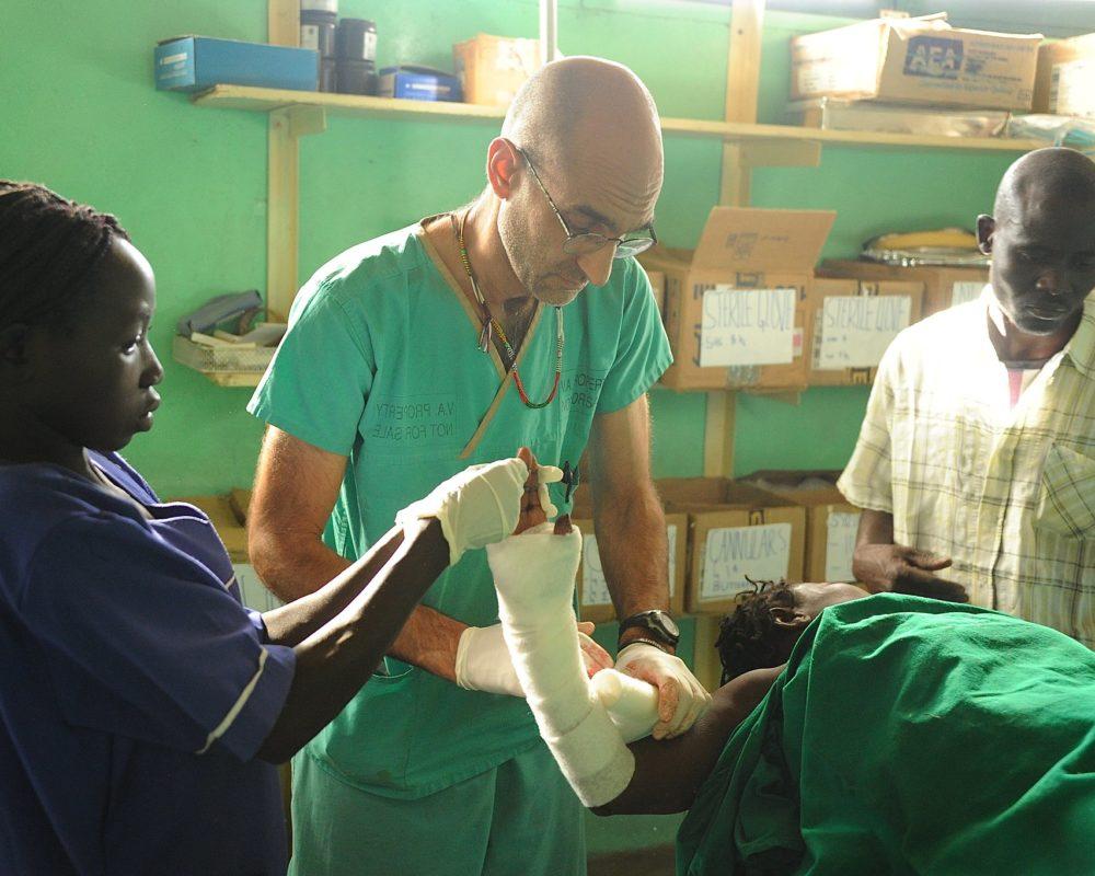 Dr. Tom is dressing a Nuba Person's arm injury