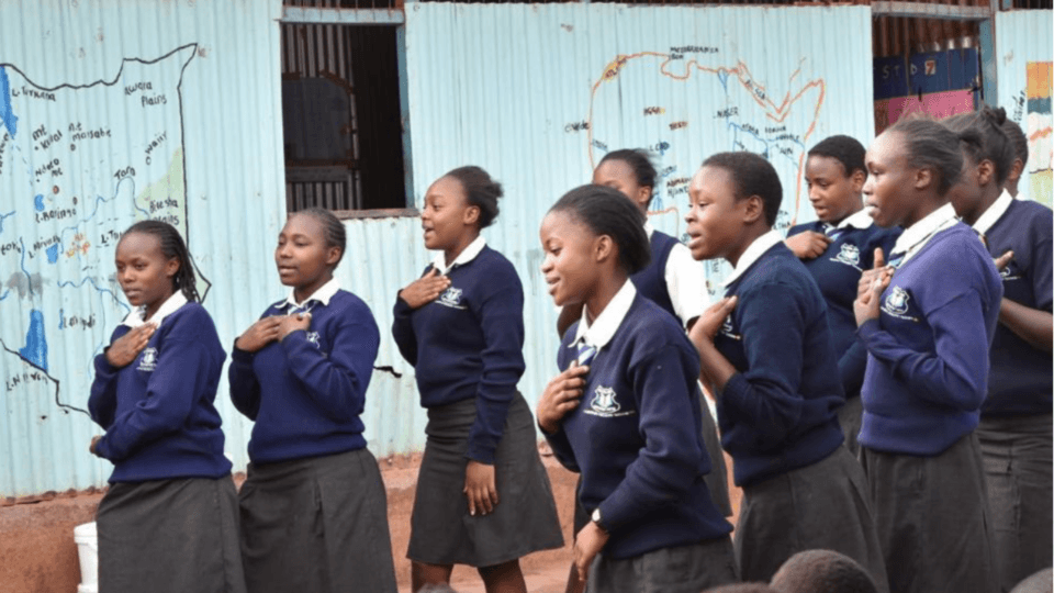 Image of the DREAMS girls reciting a poem, the caption on the photo reads, 