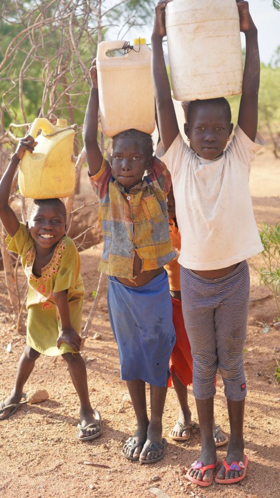 Children holding water jugs