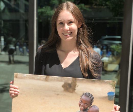 CMMB intern holds a canvas image taken in the field