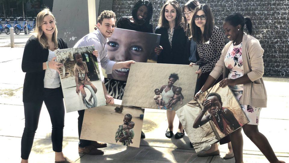 Our new interns posing together outside with canvas images of people we serve in the field