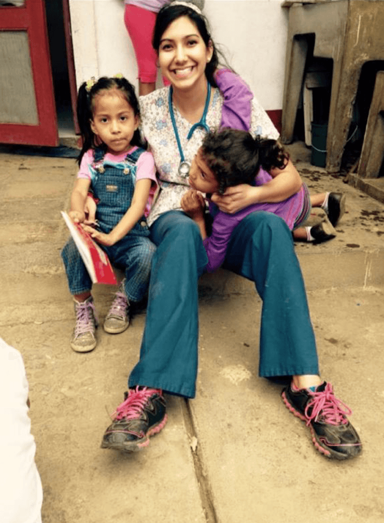 Samantha with children she served in Nicaragua. they sit together on the ground