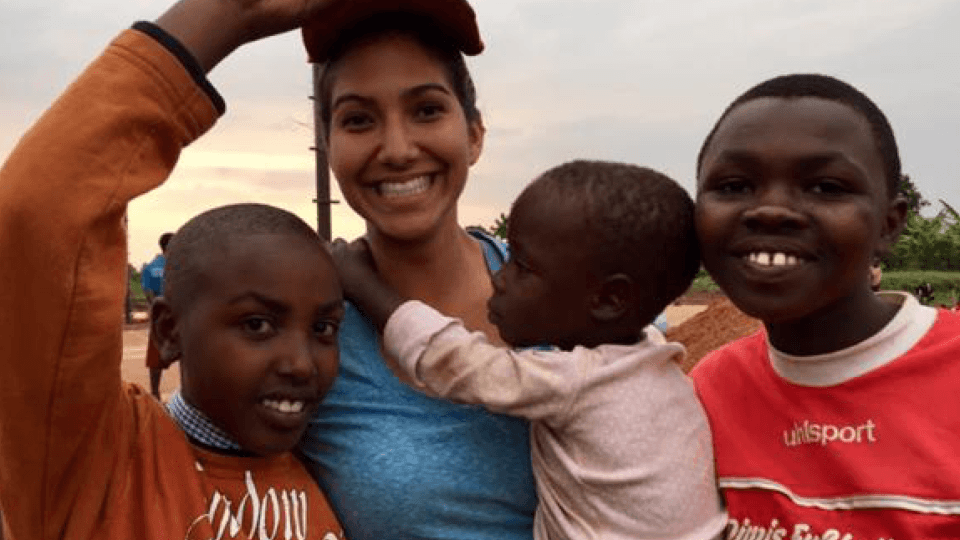 Samantha in Rwanda with children she served