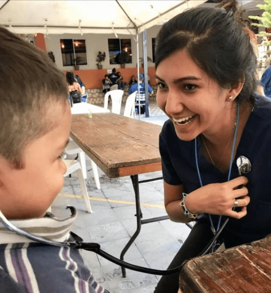 Samantha letting a little boy in El Salvador listen to her heartbeat 