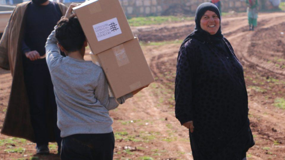 syrian woman and child carrying MFA supplies
