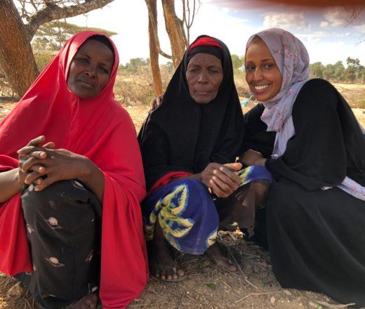 Three women including Asha Mohamed wearing head scarfs. Asha, far right, is a St. Kate's student who is completing her practicum with our team in Kenya.