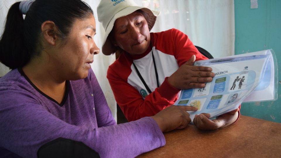 A cmmb staff member teaches a community member about gender based violence