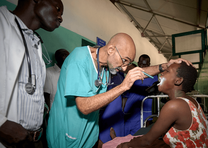 Dr. Tom Catena serving a patient. Image was originally published in America, the Jesuit Review