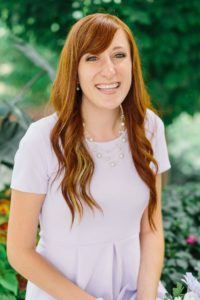 A woman with a big smile and red hair. She is one of our volunteers who will serve as a nurse assistant in Peru.