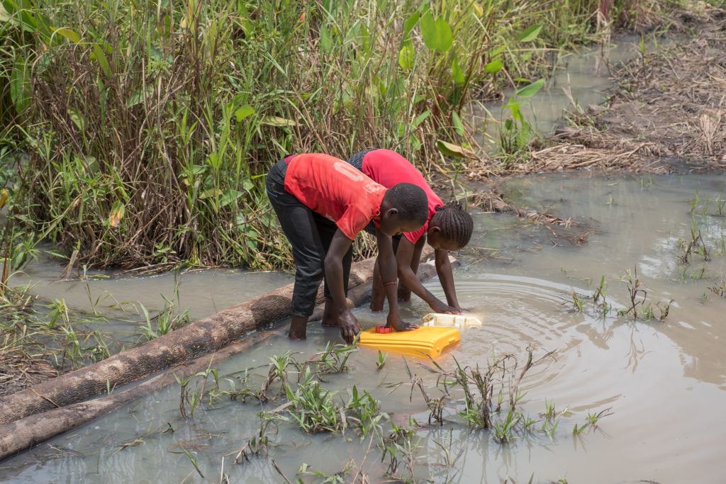 Children collect water from a riverbed