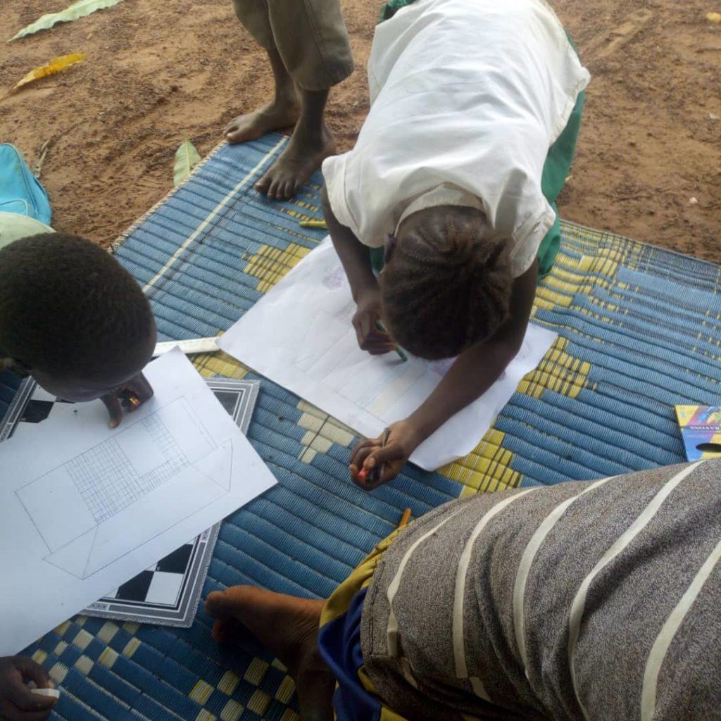 Children in South Sudan sit together and draw what peace means to them 