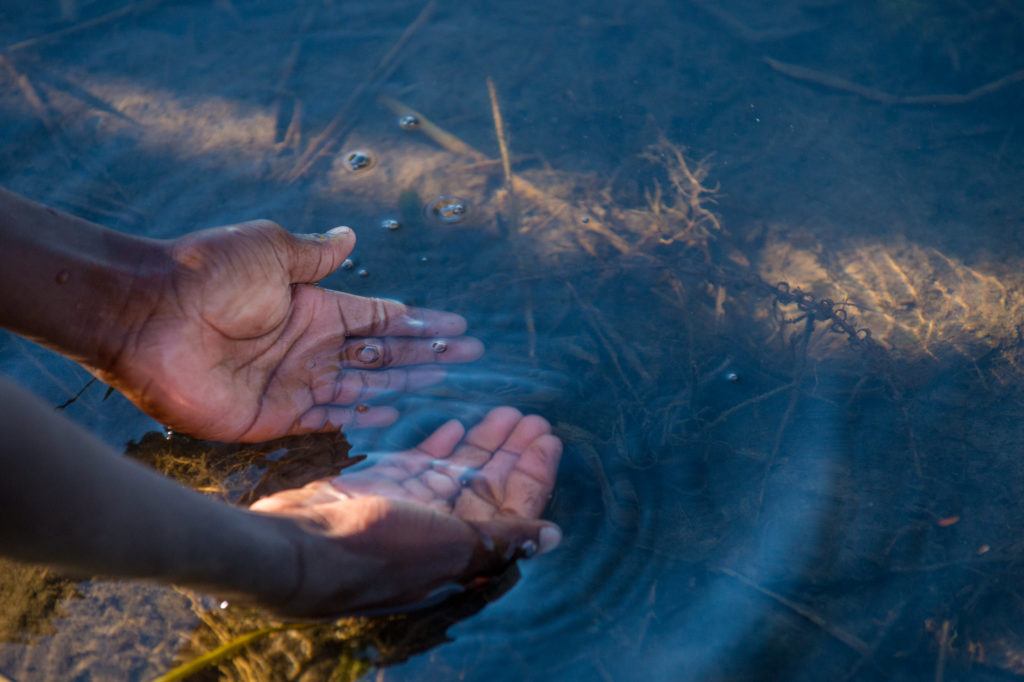 Hands in the water of a riverbed