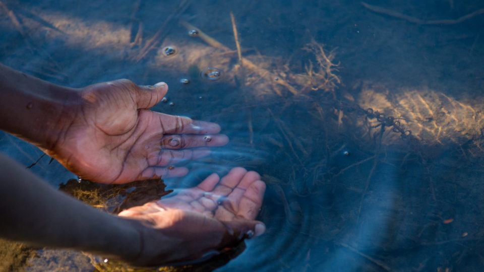 Hands in the water of a riverbed