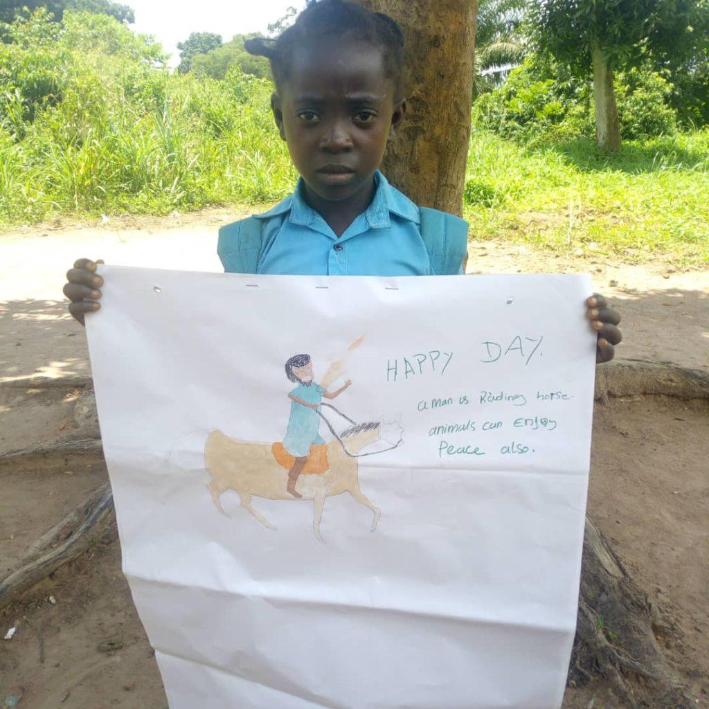 A child in South Sudan holds up a drawing of what peace means. Animals can feel peace too