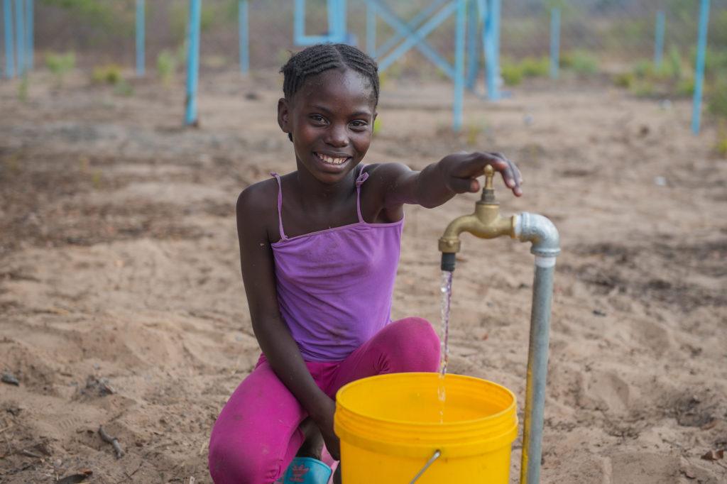 girl collecting water in zambia