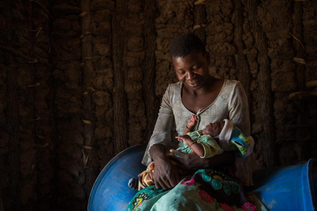 A mother holds her child in her home. At CMMB we are celebrating Mother's Day