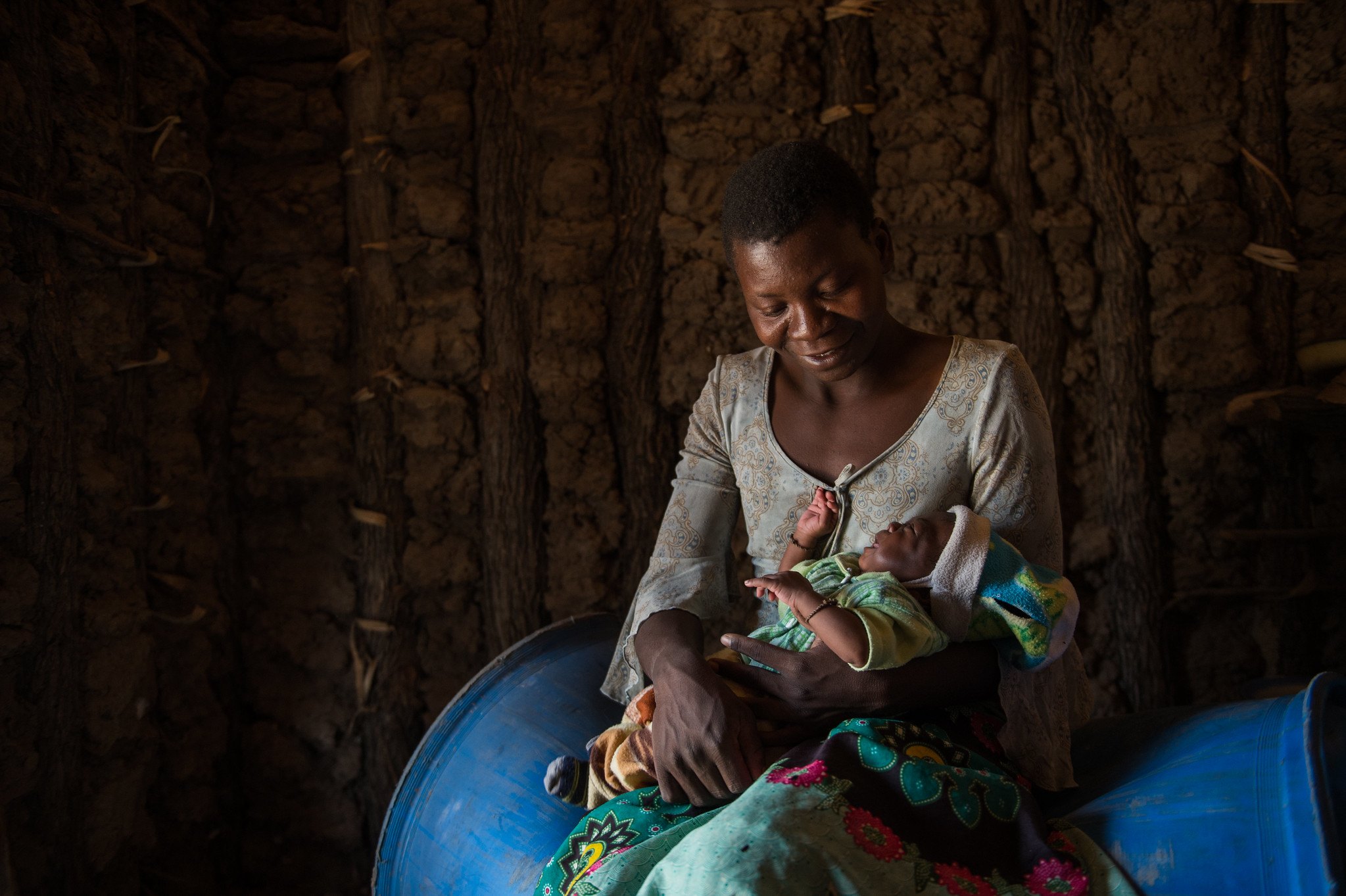 A mother holds her child in her home