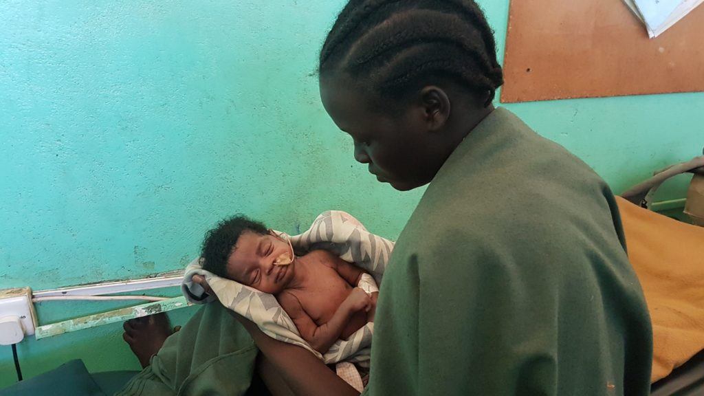 A mother looks down at her baby