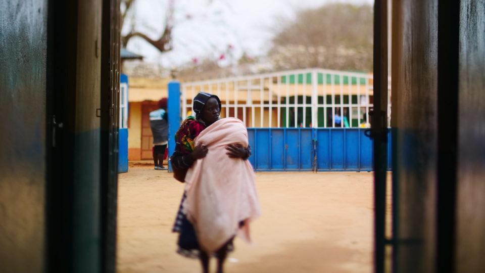 A mother walks towards to entrance of the hospital