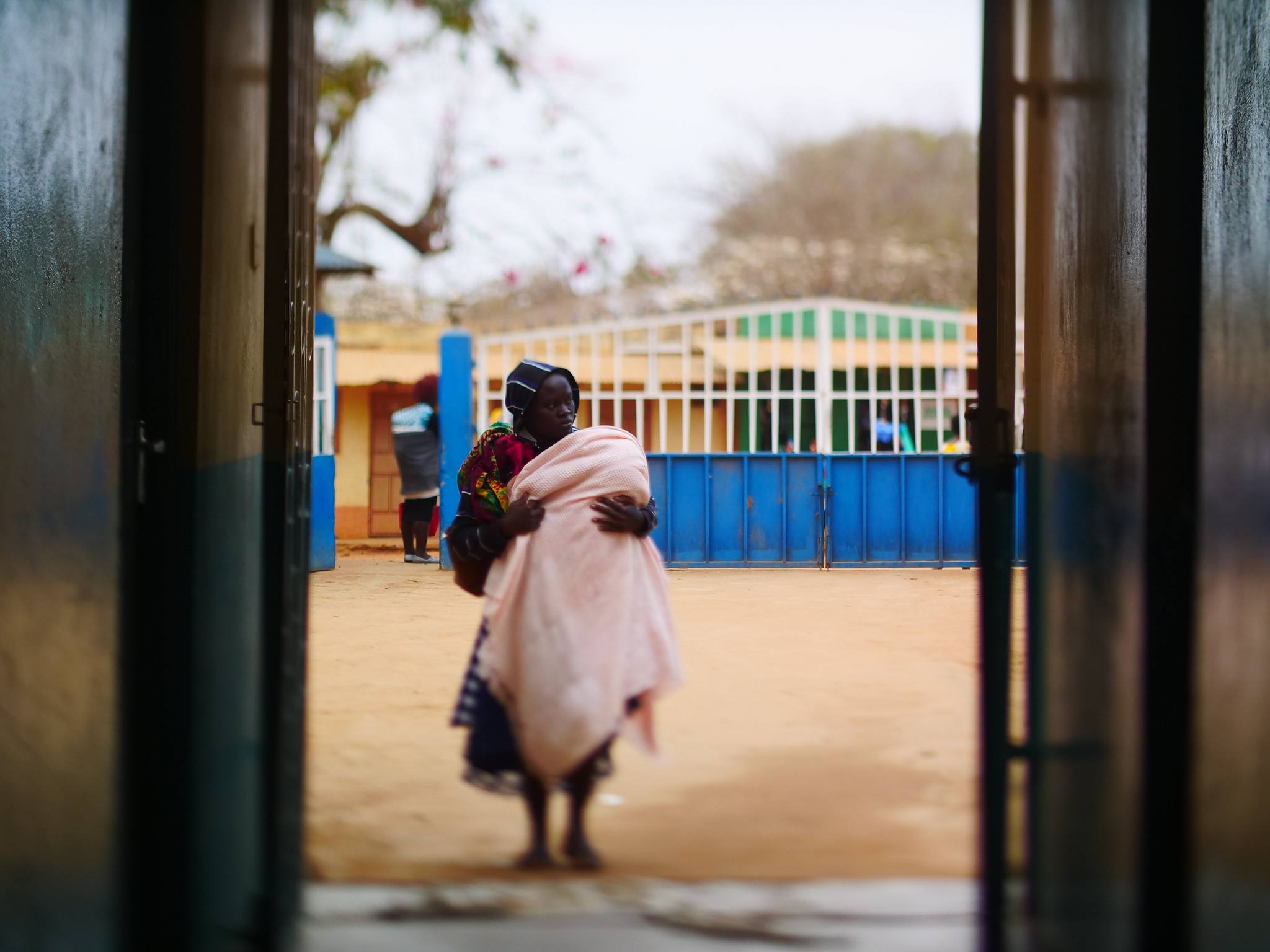 A mother walks towards to entrance of the hospital