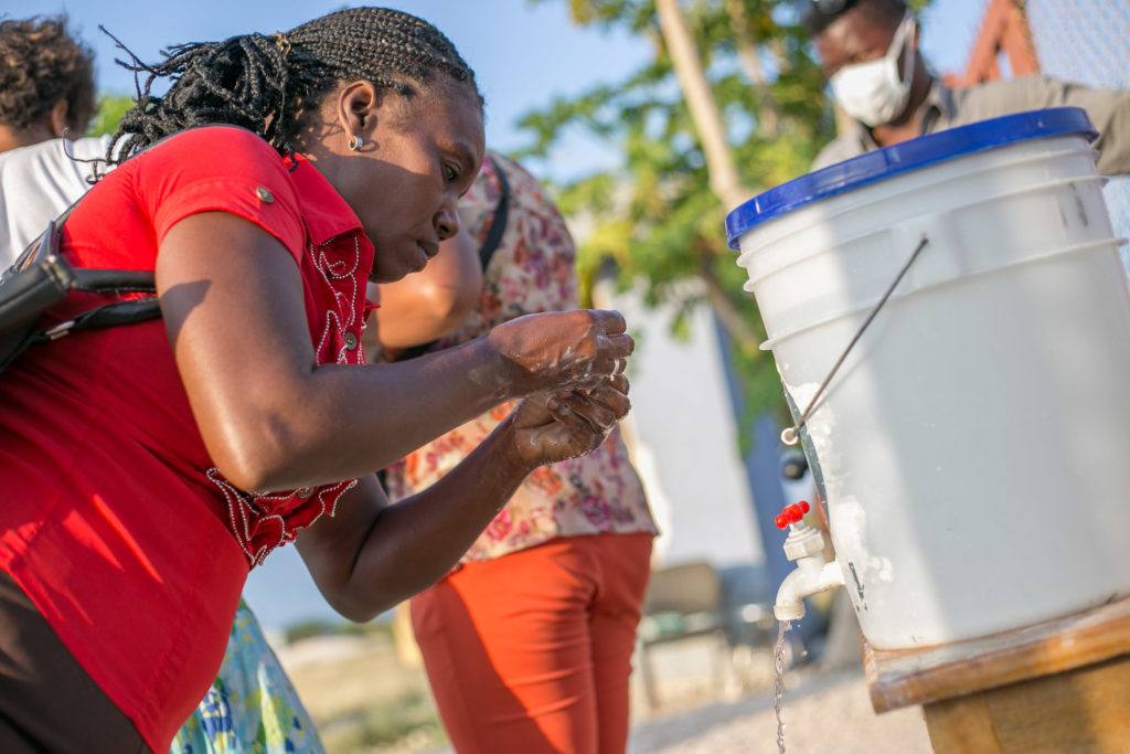 A woman washes her hands at designated hand washing stations