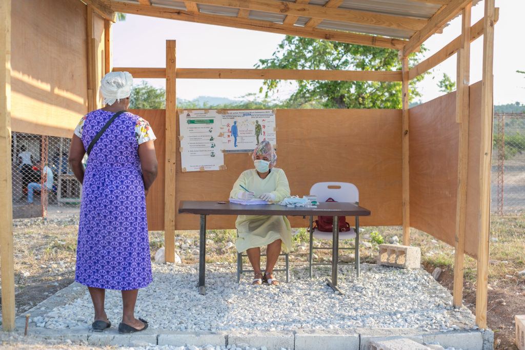 A patient waits outside at screening center in Haiti