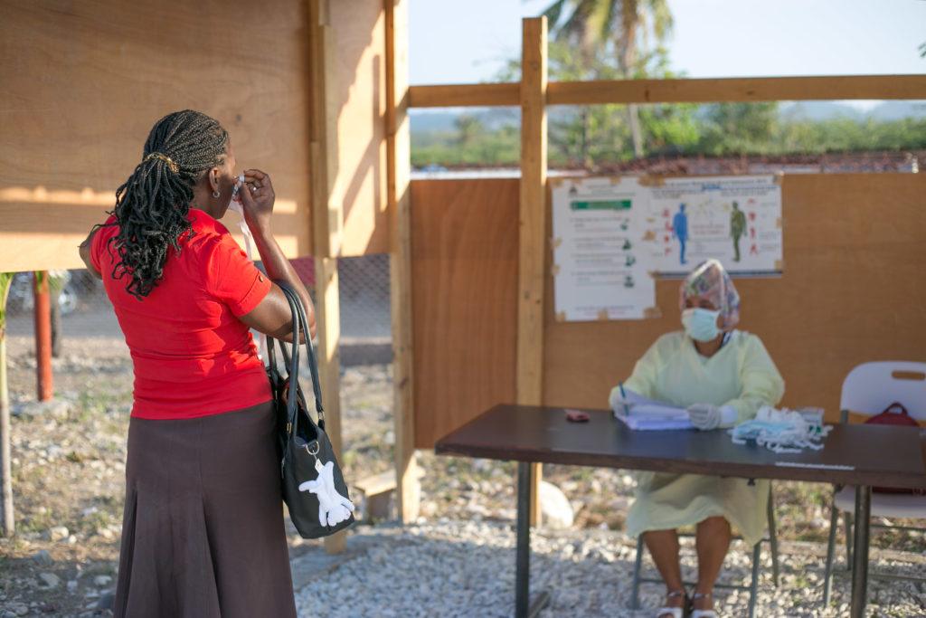 A woman waits at a check in center in Covid-19