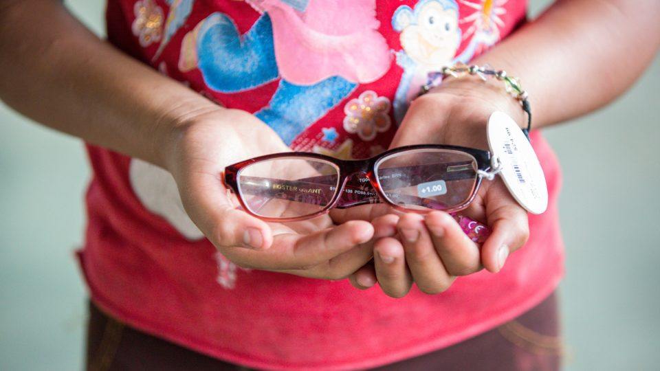 Restoring_Vision A girl holds glasses in her hands