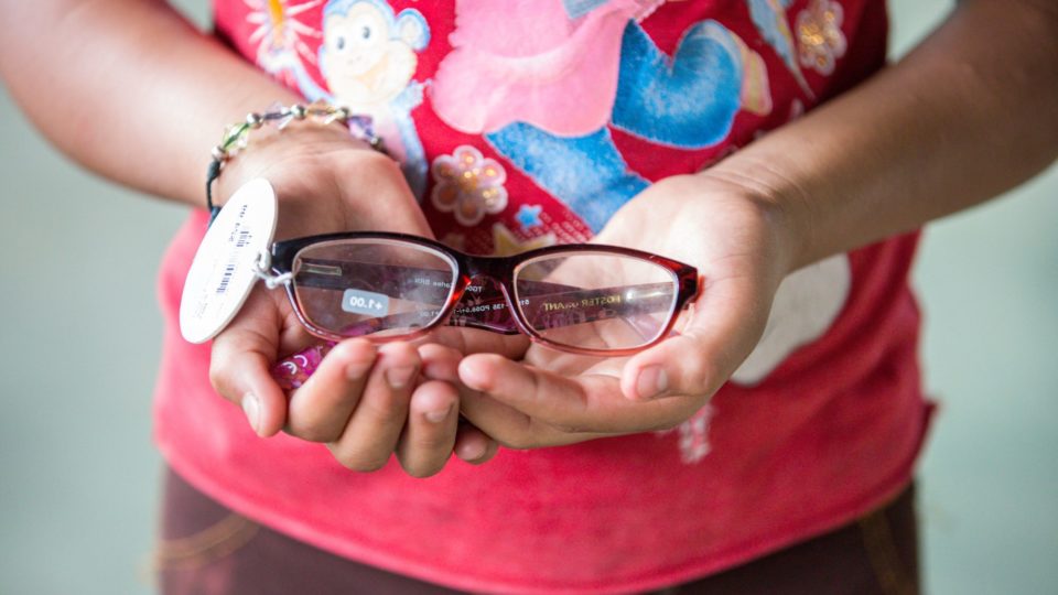 A girl holds glasses in her hands