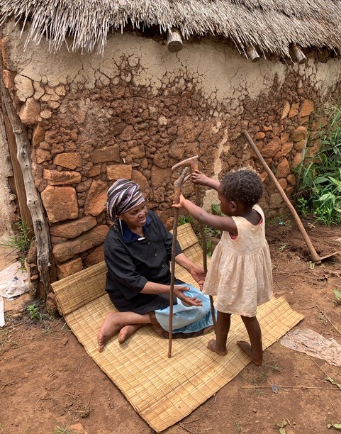 A home-based care patient sits outside her home in Swaziland