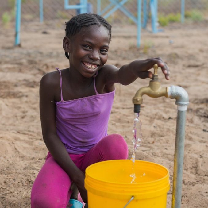 Young Girl with Clean Water Pouring from Faucet into Bucket