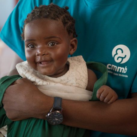 A baby girl being held by a community health worker in Mwandi, Zambia in October 2019.