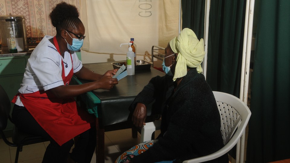 A healthcare worker with a patient before a cervical cancer screening in Kenya in June 2020.