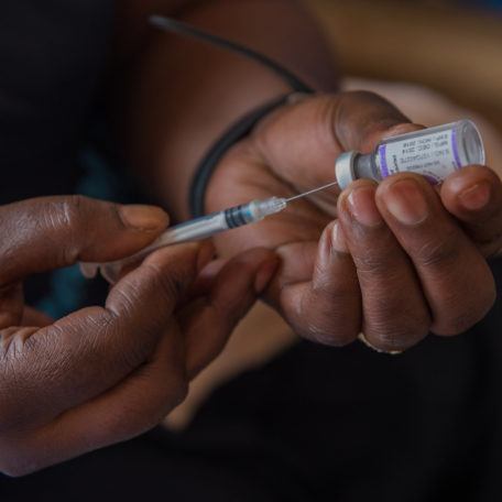 A hand with a syringe drawing medicine from a vial in Zambia in December 2015