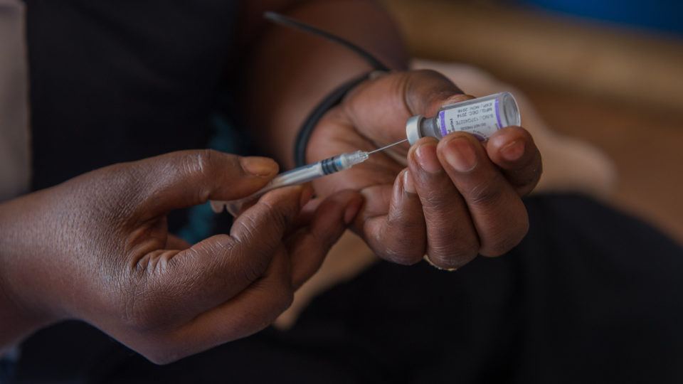 A hand with a syringe drawing medicine from a vial in Zambia in December 2015