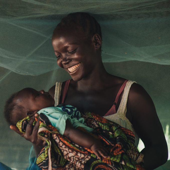 Mother-Child-South-Sudan-October-2018 A mother holdering her infant child beneath a net in South Sudan in Octob 2018.