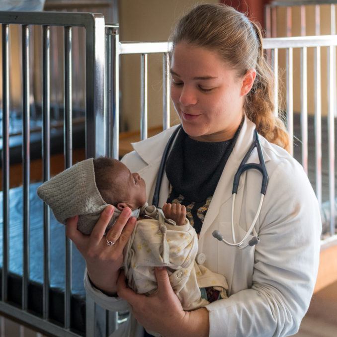 A volunteer doctobr holds an infant at Mwandi Mission Hospital in Zambia in June 2018.