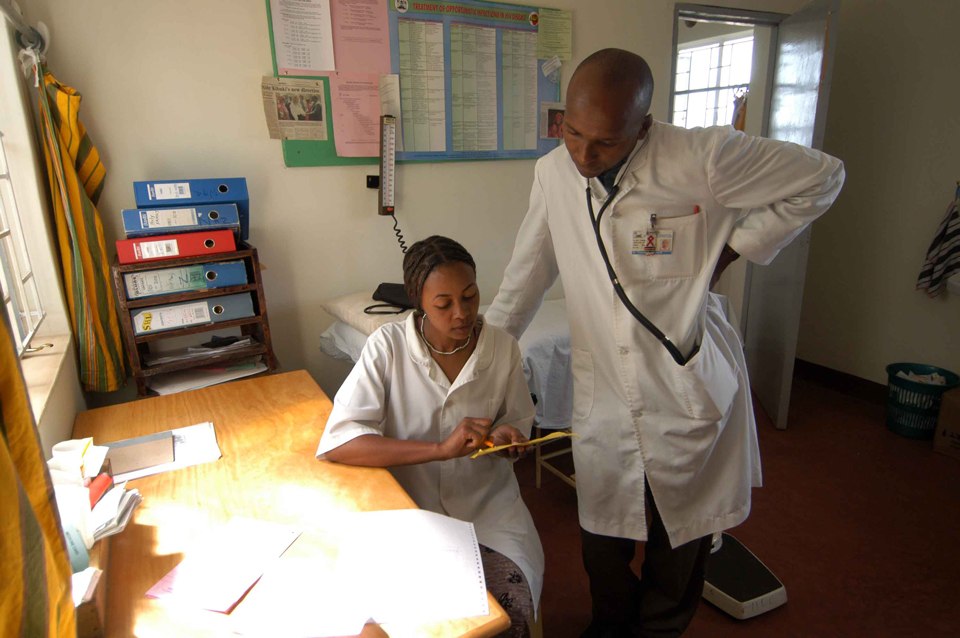 A health worker and a doctor look at records together at a hospital in Kenya in March 2005.