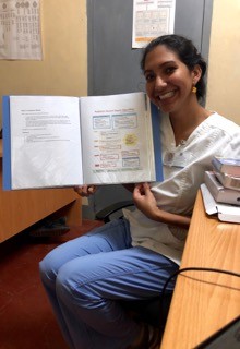 Samantha holds a medical reference book created for staff at the Mutomo Mission Hospital in Kenya in 2019