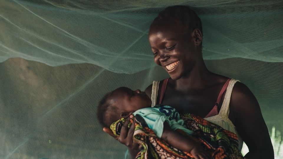 Mom smiles while holding her baby_South Sudan