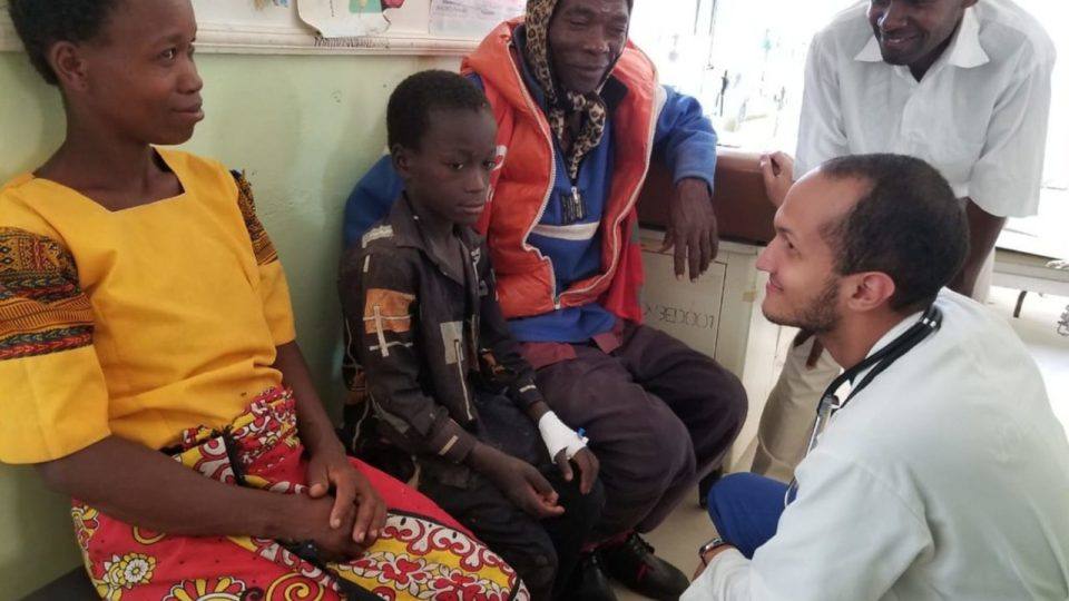 Dr. Jose speaks to a young patient in Kenya in 2019