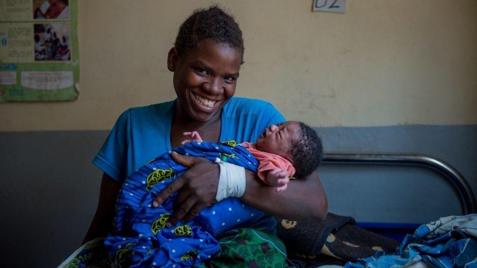 A mom an infant are treated at at rural health facility in Mwandi