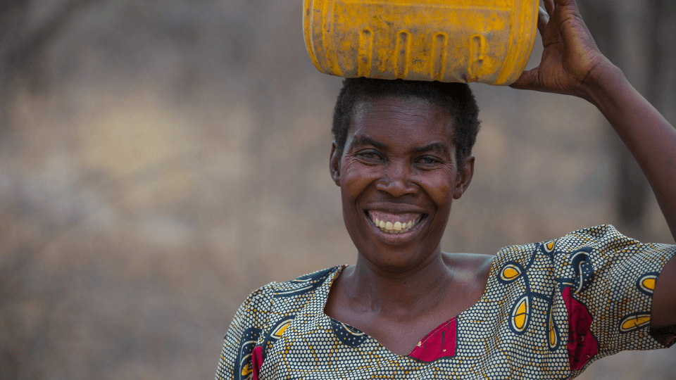 A woman carries water in a jerrycan in Zambia