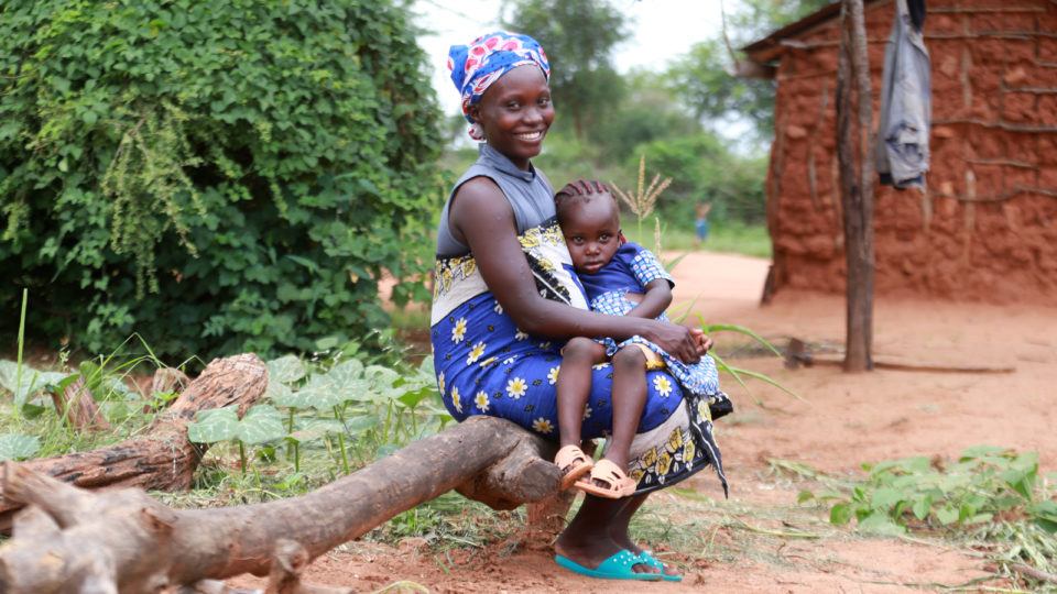 A mother in rural Kenya with her daughter sitting on her lap in 2021.