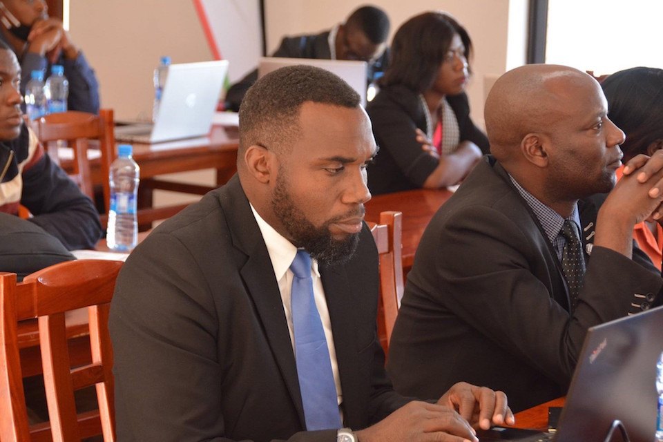 Henry Mshoka sits with colleagues 