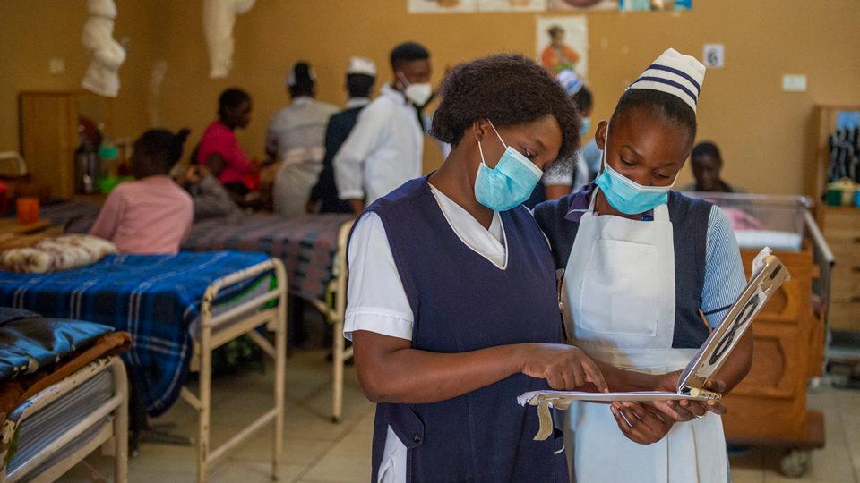 Healthcare workers reading a chart at Mwandi Mission Hospital in Zambia in May 2021.